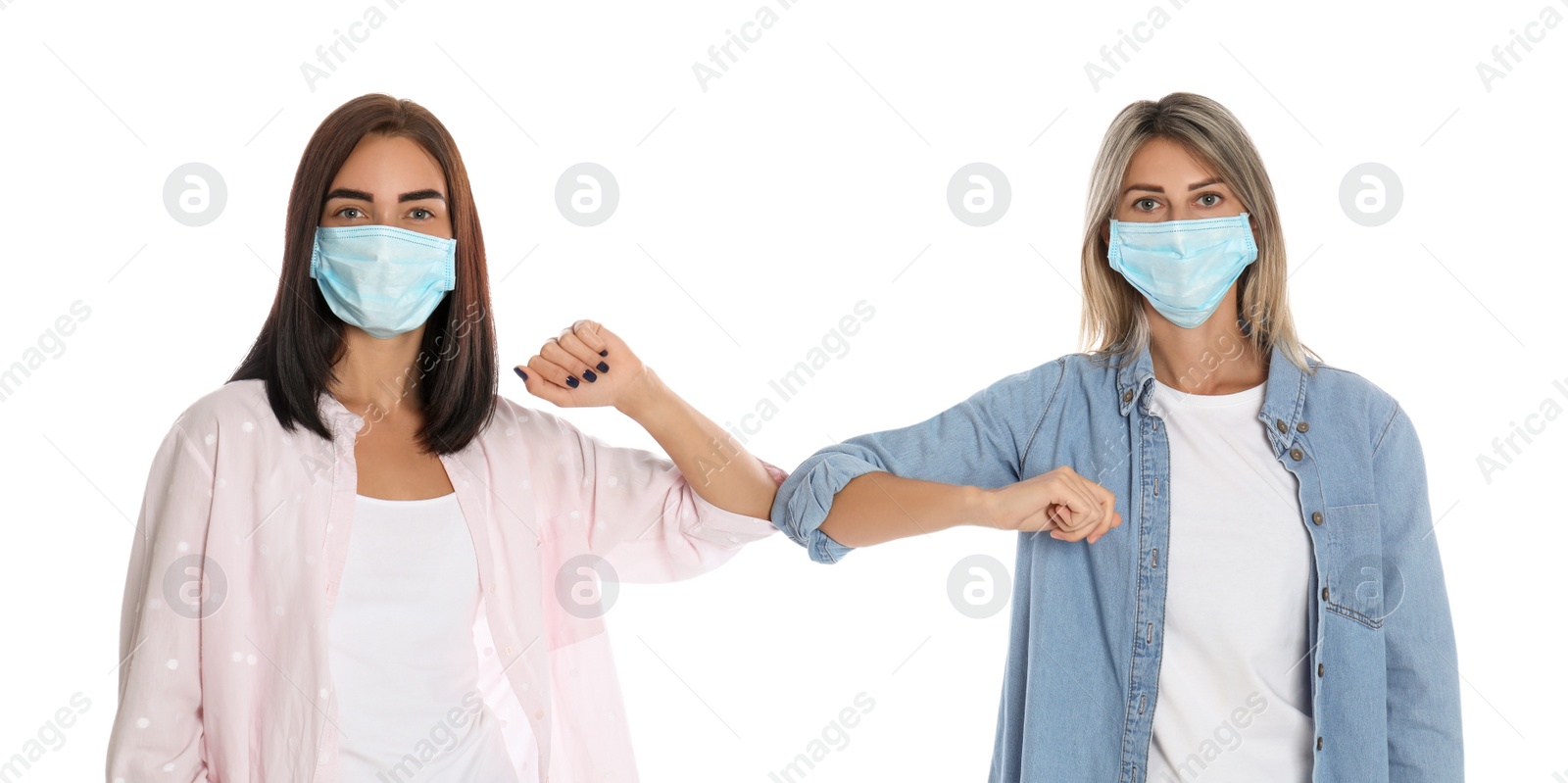 Photo of Women bumping elbows to say hello on white background. Keeping social distance during coronavirus pandemic