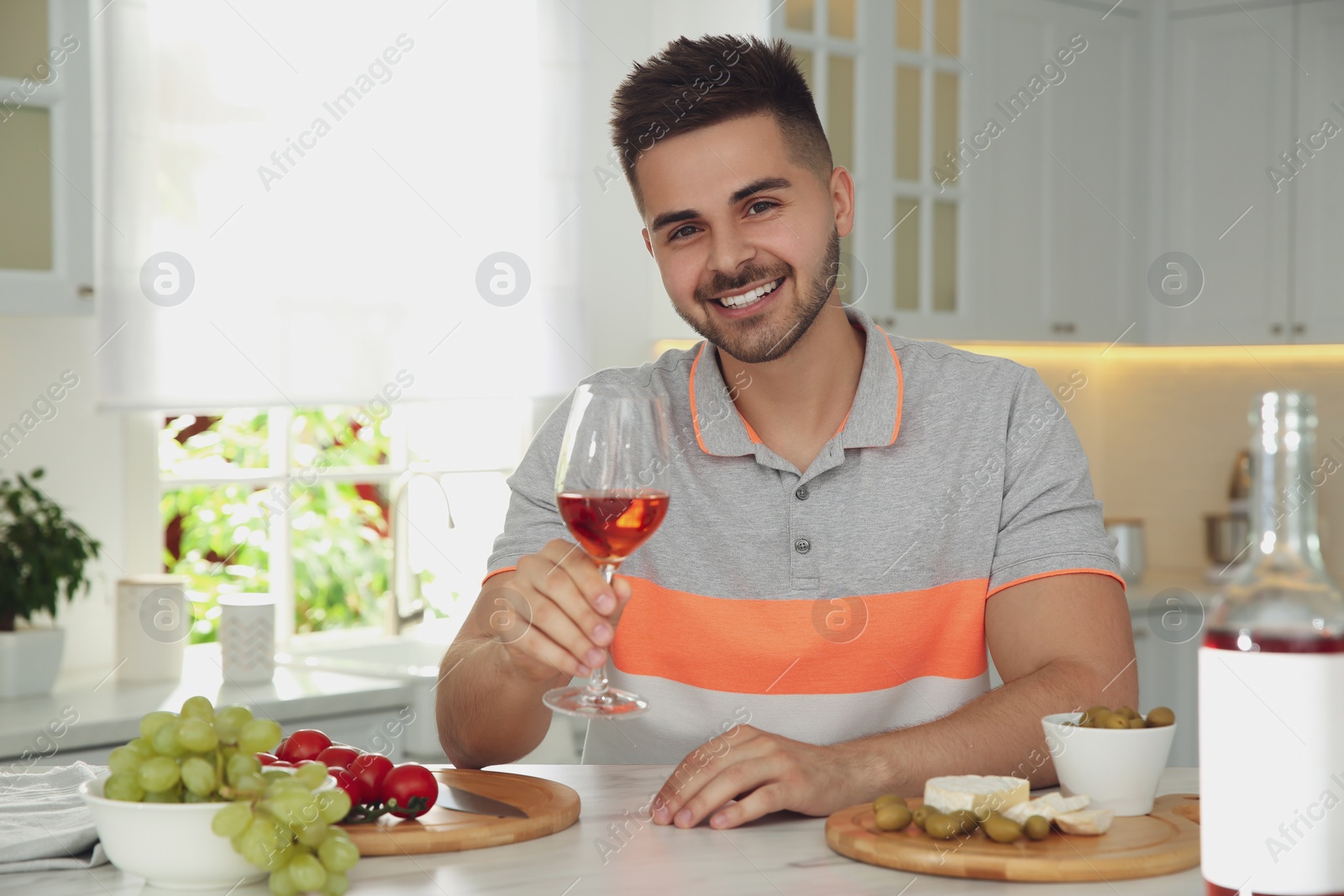 Photo of Man drinking wine while having online video conference at home, view from web camera. Social distancing during coronavirus pandemic