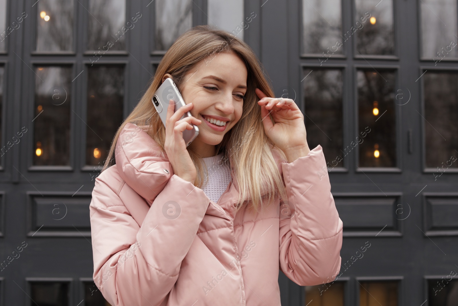 Photo of Young woman talking on mobile phone outdoors