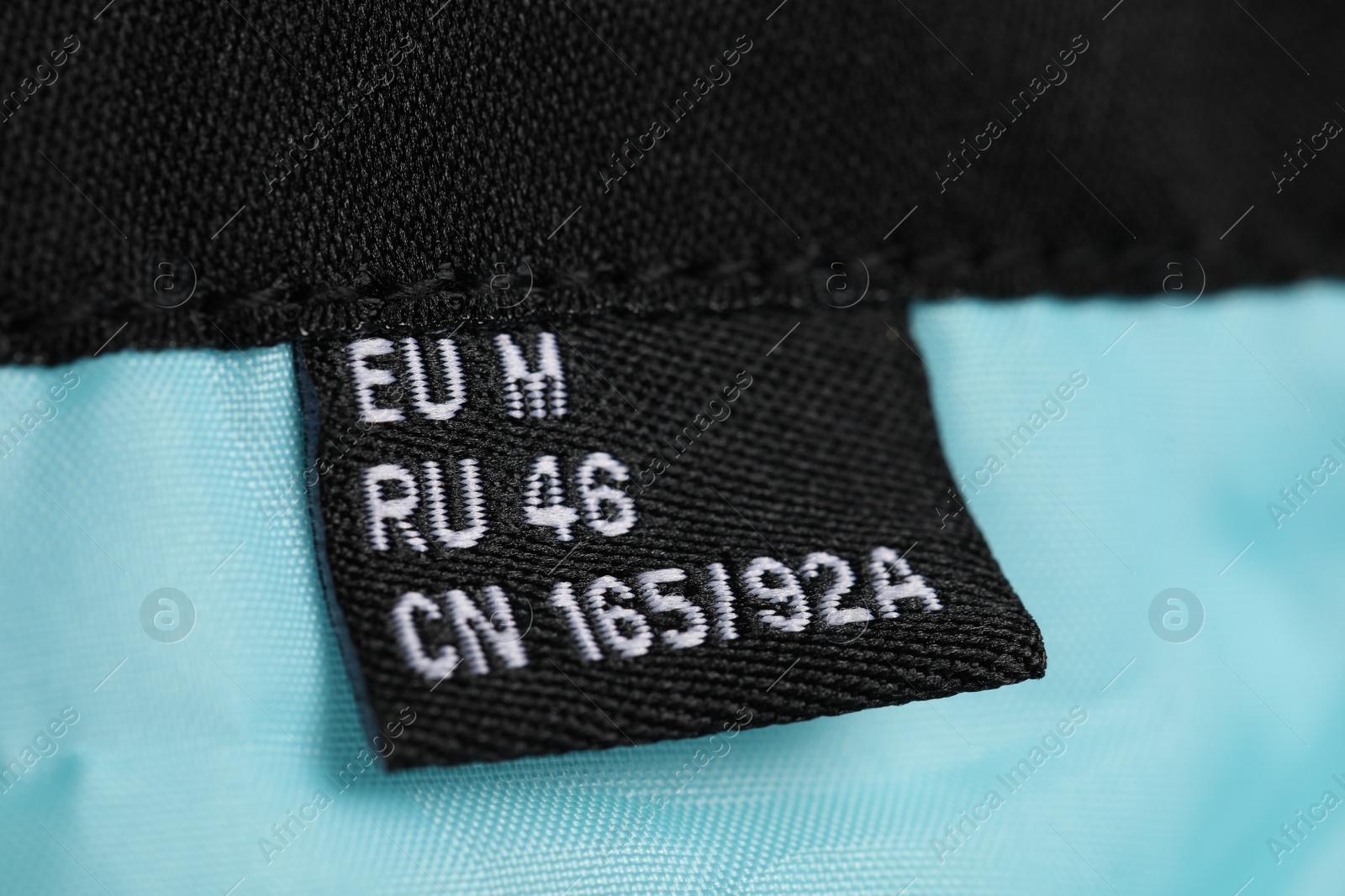 Photo of Clothing label on turquoise garment, closeup view