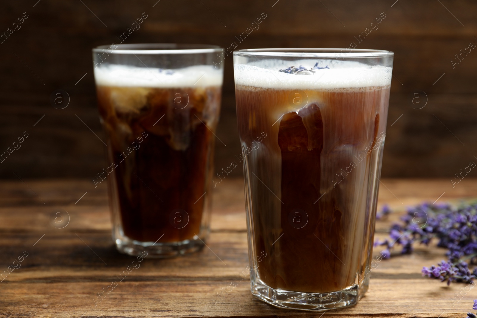 Photo of Delicious coffee with lavender on wooden table, closeup