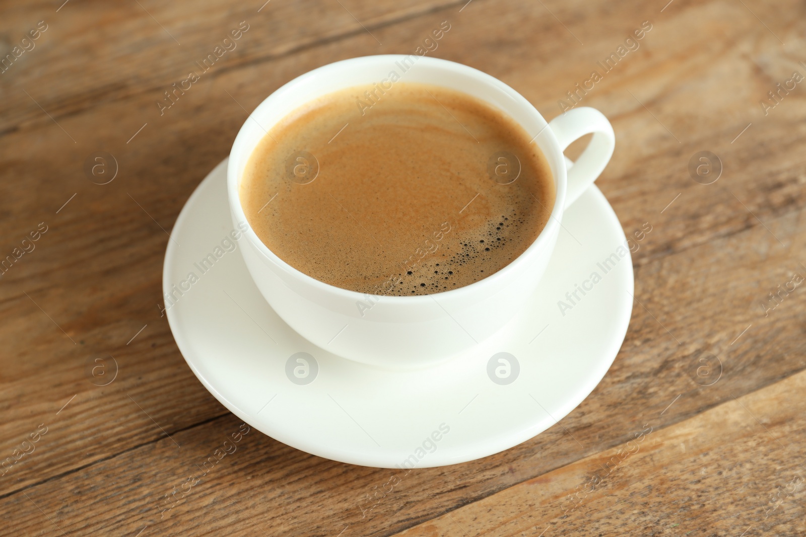 Photo of Cup of tasty coffee on wooden table