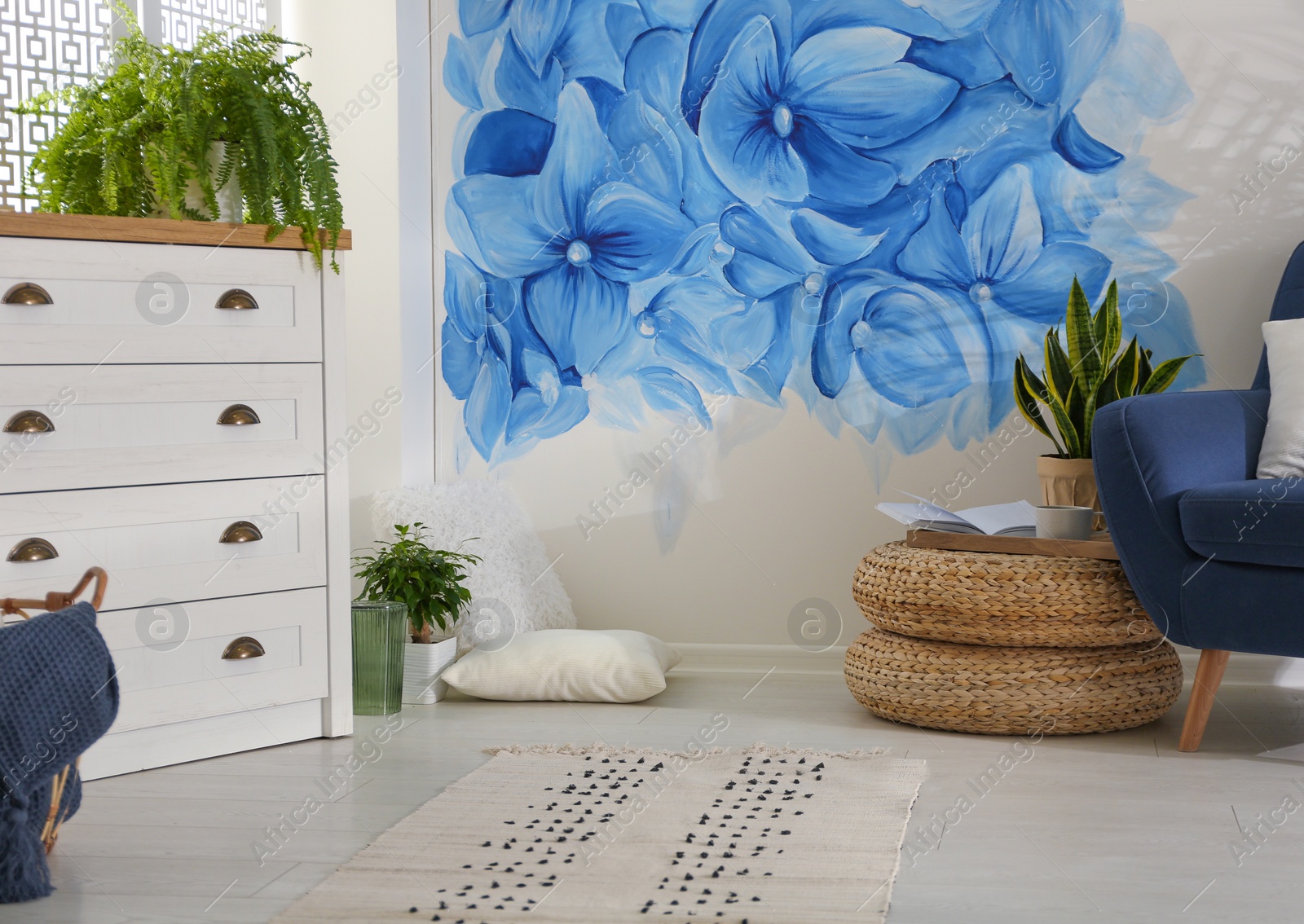 Photo of Stylish living room with blue flowers painted on wall. Floral pattern in interior design