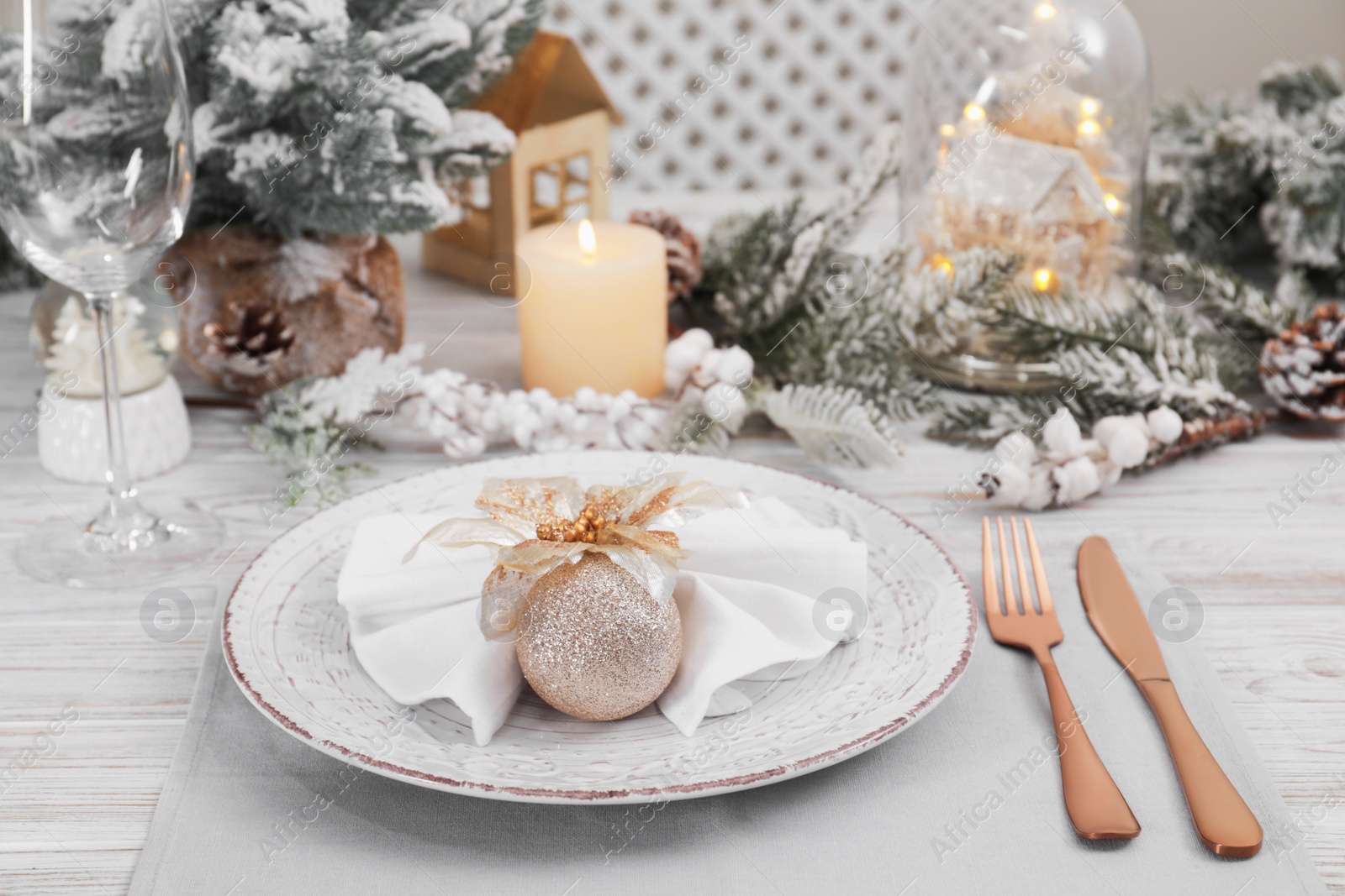 Photo of Festive place setting with beautiful dishware, cutlery and decor for Christmas dinner on white wooden table