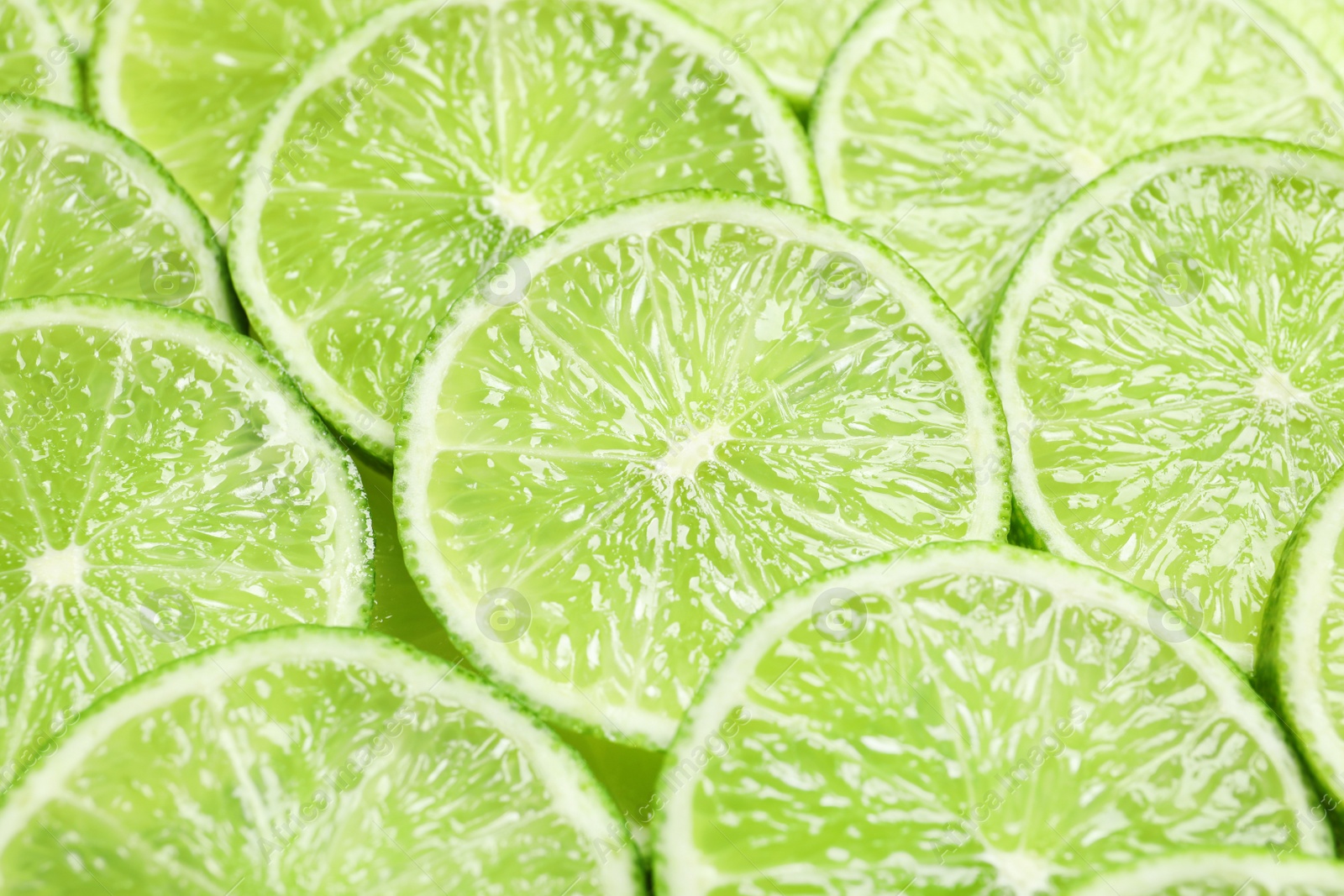 Photo of Fresh sliced ripe limes as background, closeup