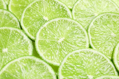 Photo of Fresh sliced ripe limes as background, closeup