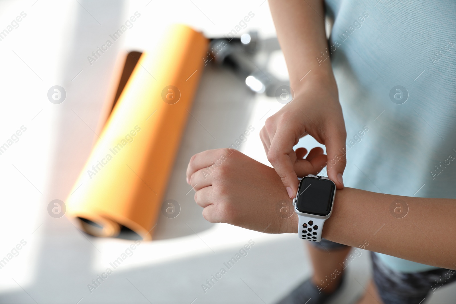 Photo of Woman checking fitness tracker in gym, closeup