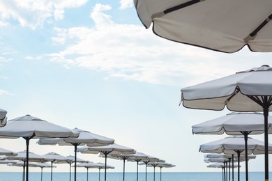 Photo of Beautiful white beach umbrellas against blue sky