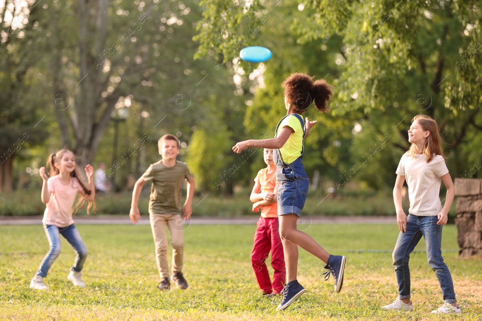 Photo of Cute little children playing with frisbee outdoors on sunny day