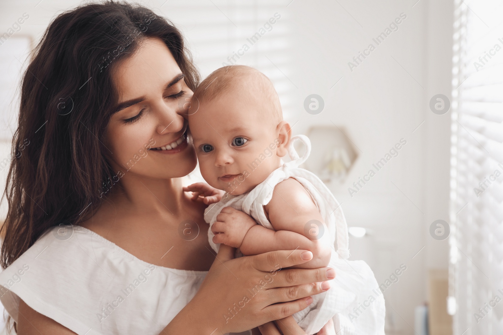 Photo of Happy young mother with her cute baby at home