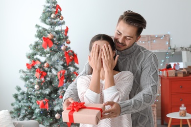 Photo of Happy young couple celebrating Christmas at home