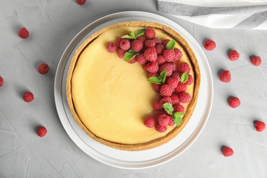 Photo of Dessert plate with delicious raspberry cake on grey table, flat lay