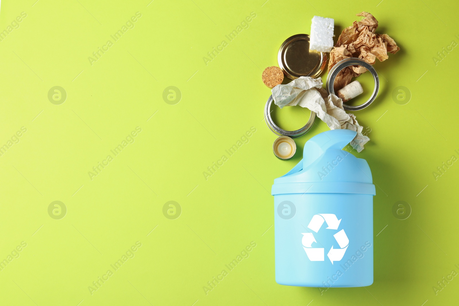 Photo of Trash bin and different garbage on color background, top view with space for text. Waste recycling concept