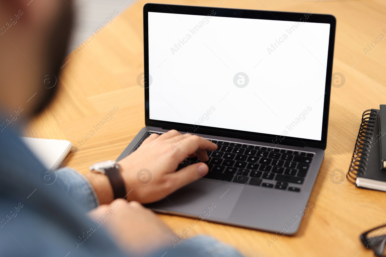 Photo of Young man watching webinar at table, closeup