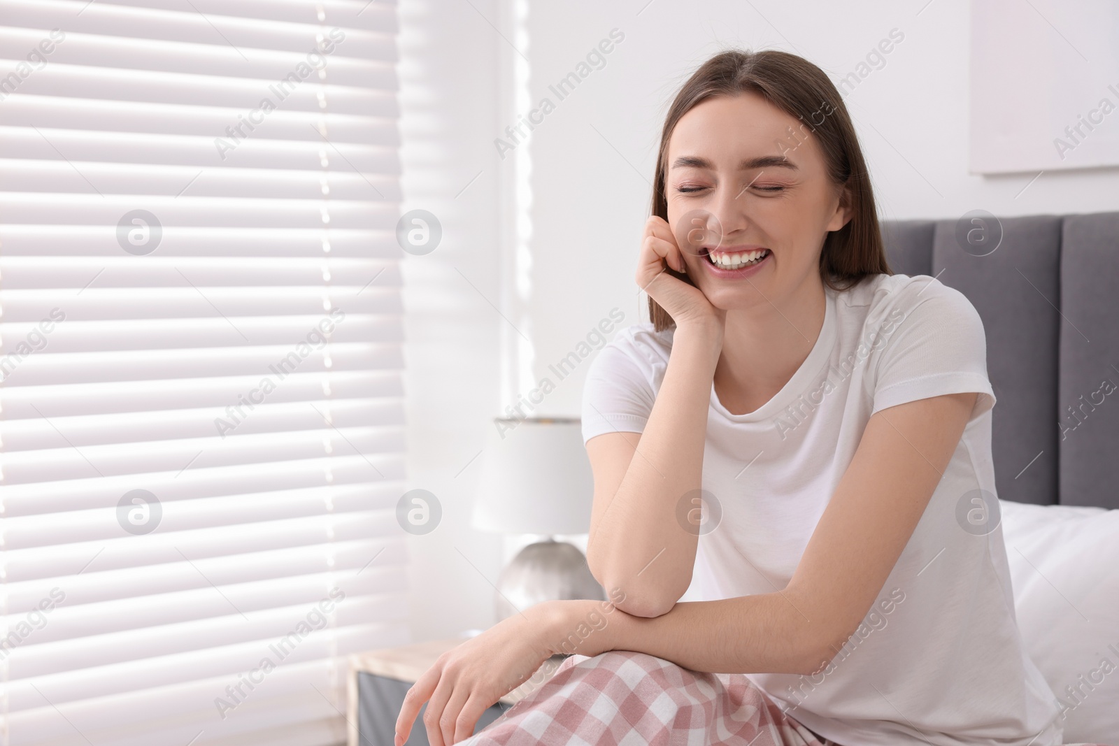 Photo of Portrait of beautiful woman laughing in bedroom. Space for text