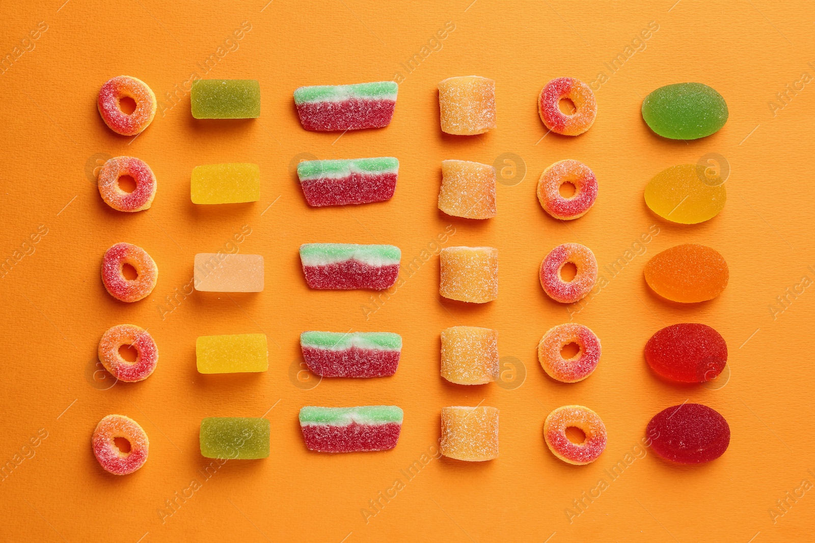 Photo of Flat lay composition with delicious jelly candies on color background