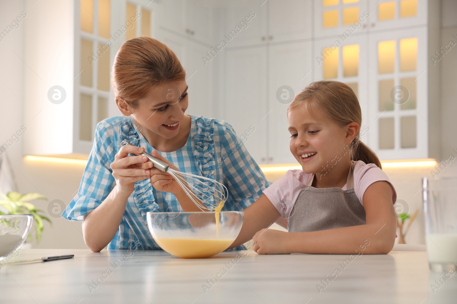 Photo of Mother and daughter making dough together in kitchen