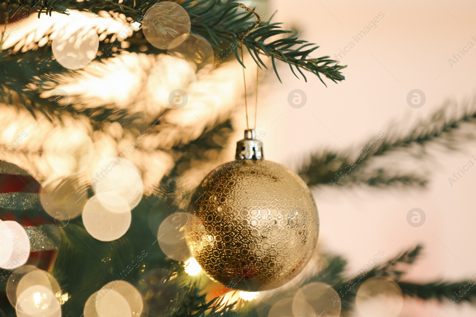 Photo of Christmas tree decorated with festive balls on light background, closeup
