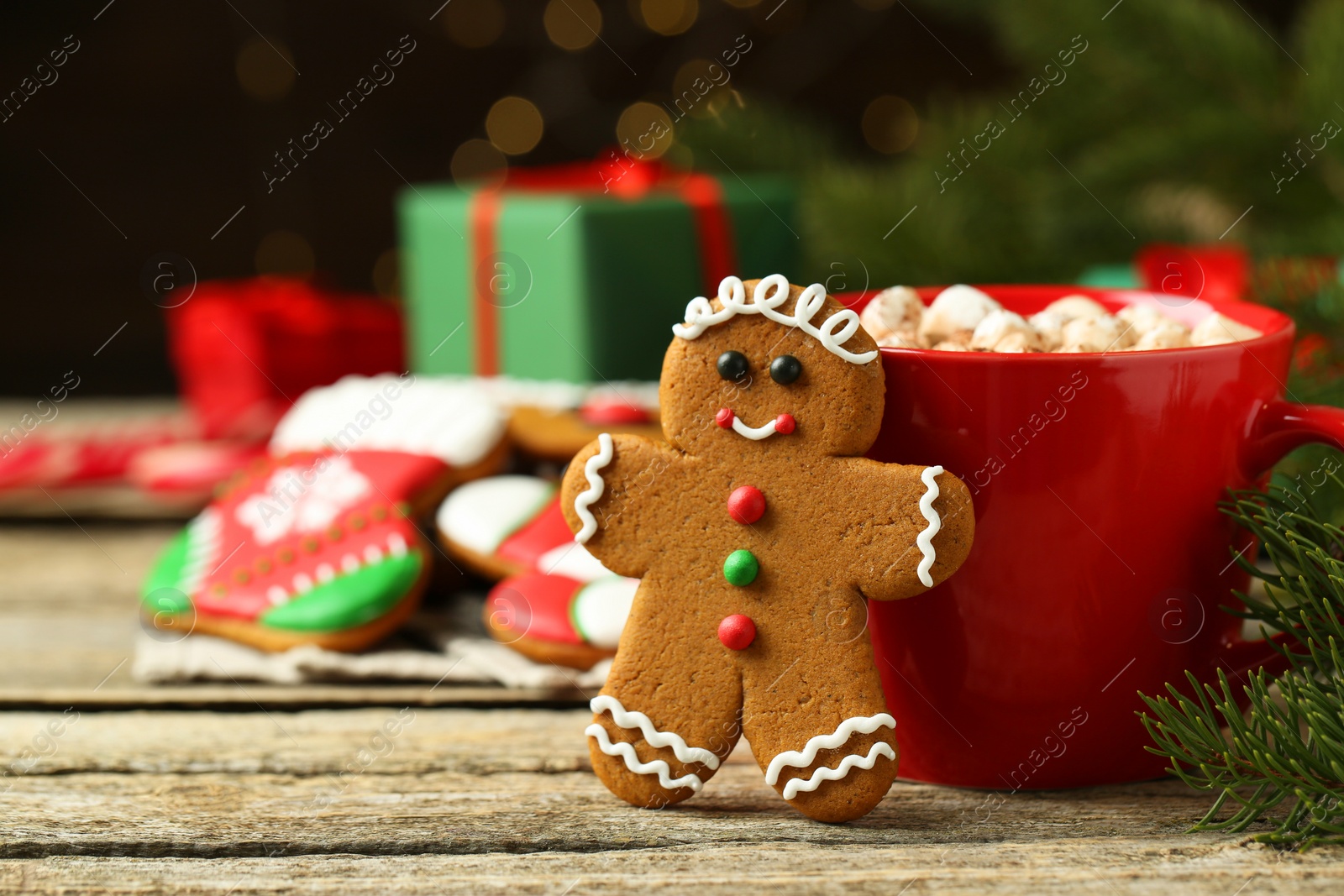 Photo of Tasty gingerbread man cookie and cocoa with marshmallows on wooden table. Space for text