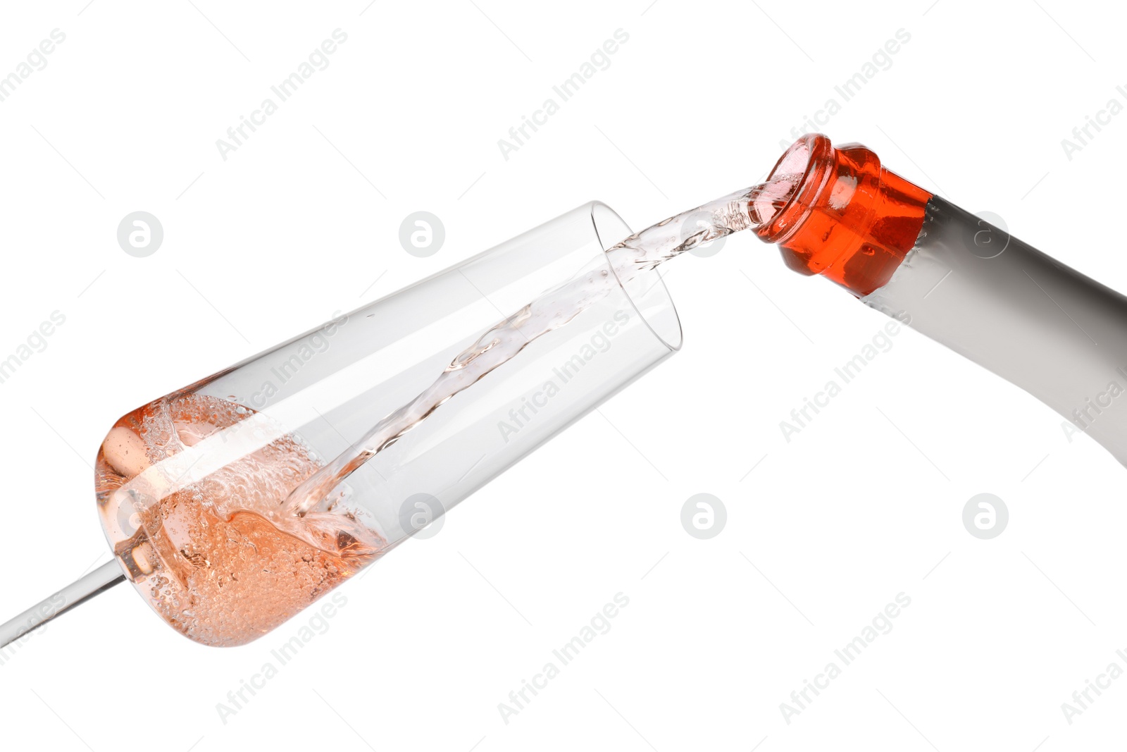 Photo of Rose champagne pouring from bottle into glass isolated on white