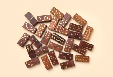 Wooden domino tiles on beige background, flat lay