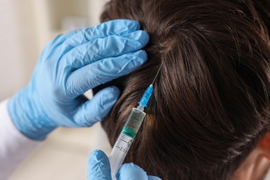 Trichologist giving injection to patient in clinic, closeup