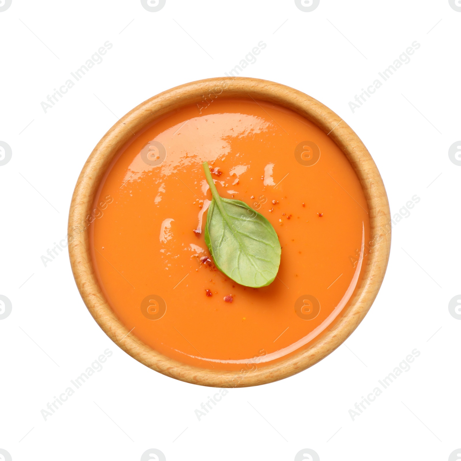 Photo of Tasty creamy pumpkin soup with basil in bowl on white background, top view