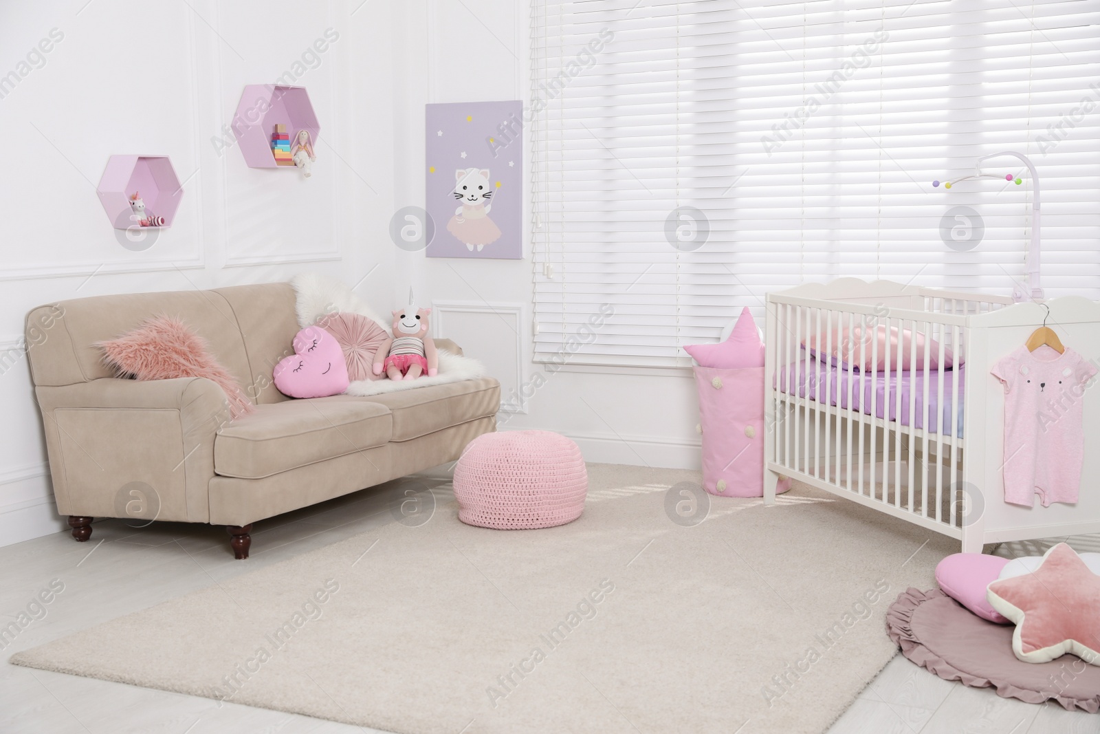 Photo of Cozy baby room with crib and sofa. Interior design