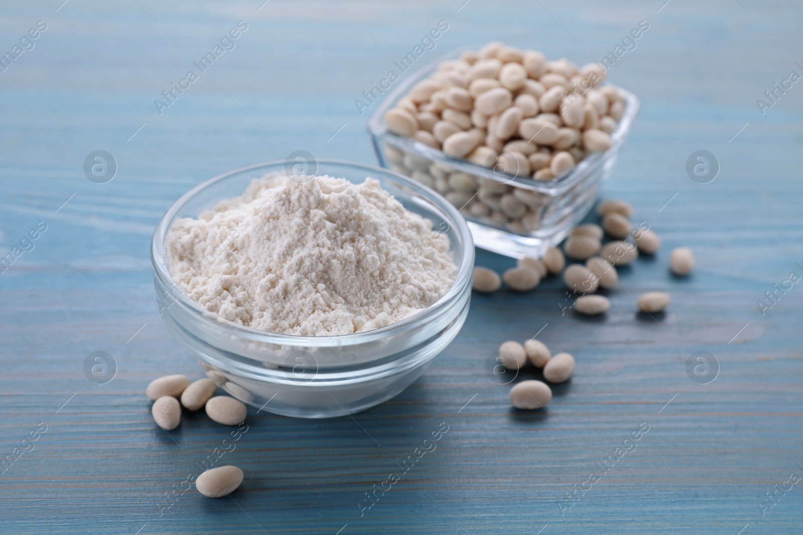 Photo of Kidney bean flour and seeds on light blue wooden table