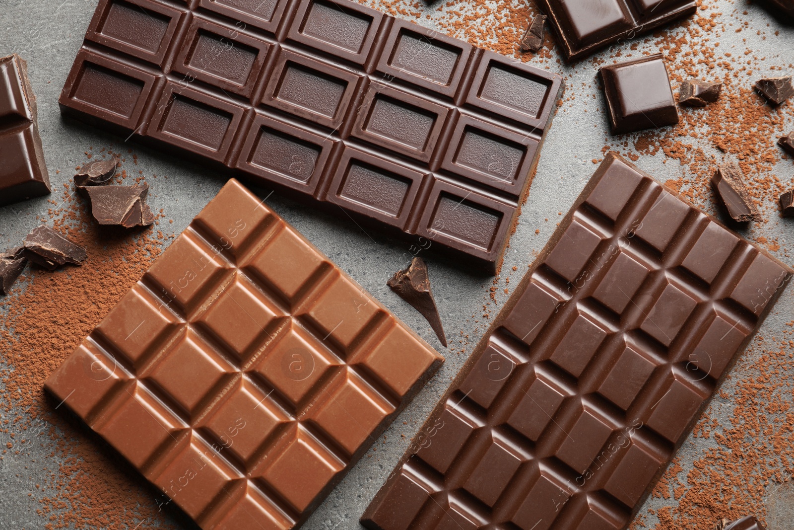 Photo of Different kinds of chocolate on grey background, top view