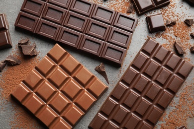 Photo of Different kinds of chocolate on grey background, top view