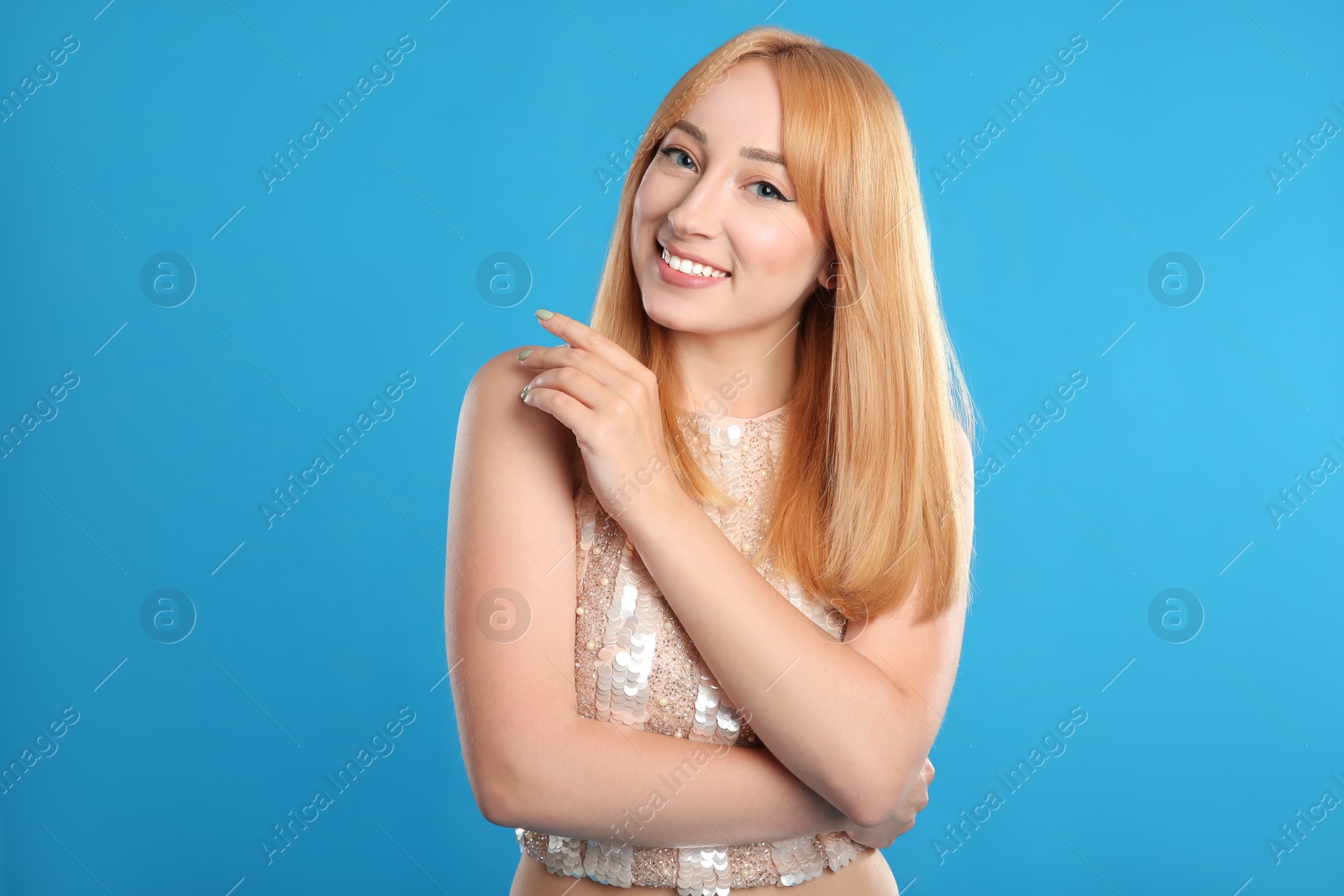 Photo of Portrait of beautiful young woman with blonde hair on blue background