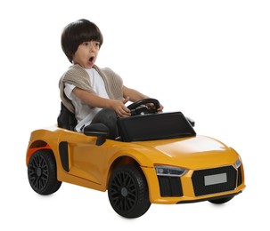 Cute little boy driving children's electric toy car on white background