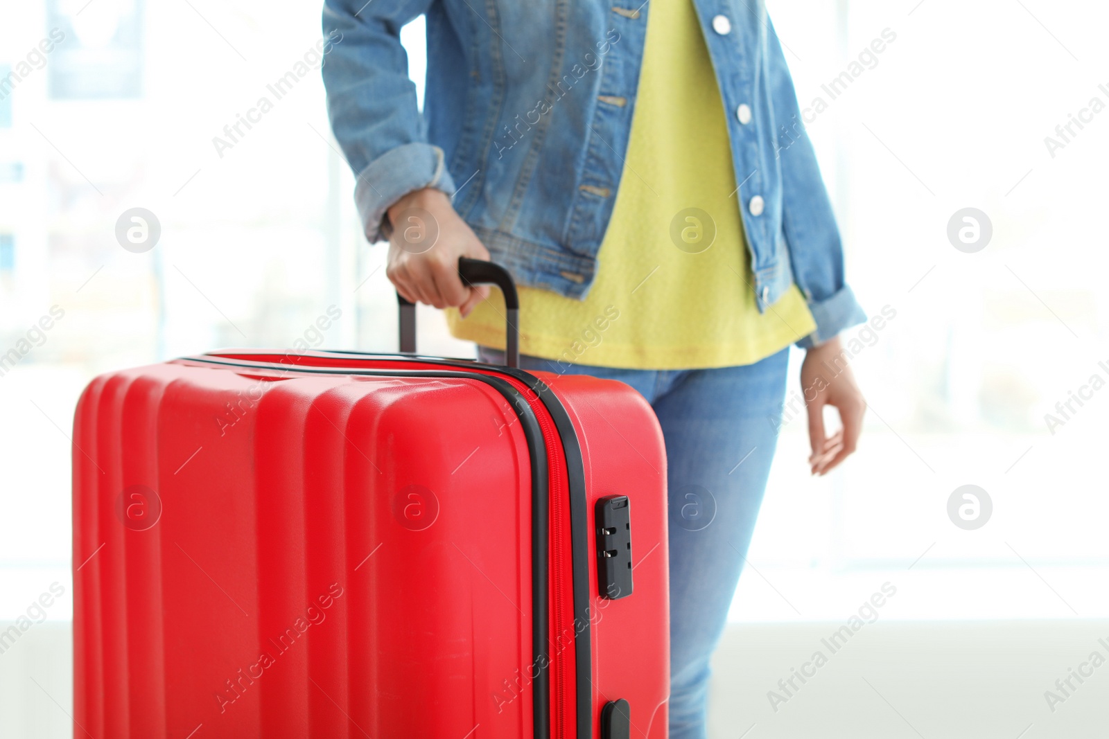 Photo of Young woman with suitcase indoors