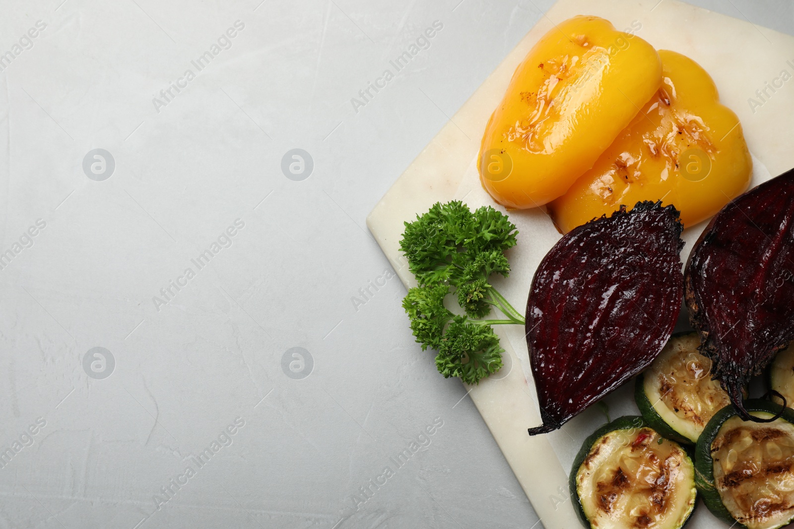 Photo of Delicious grilled vegetables on light table, top view. Space for text