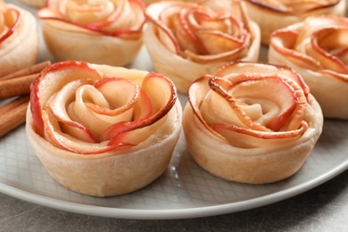 Photo of Freshly baked apple roses on grey table, closeup. Beautiful dessert