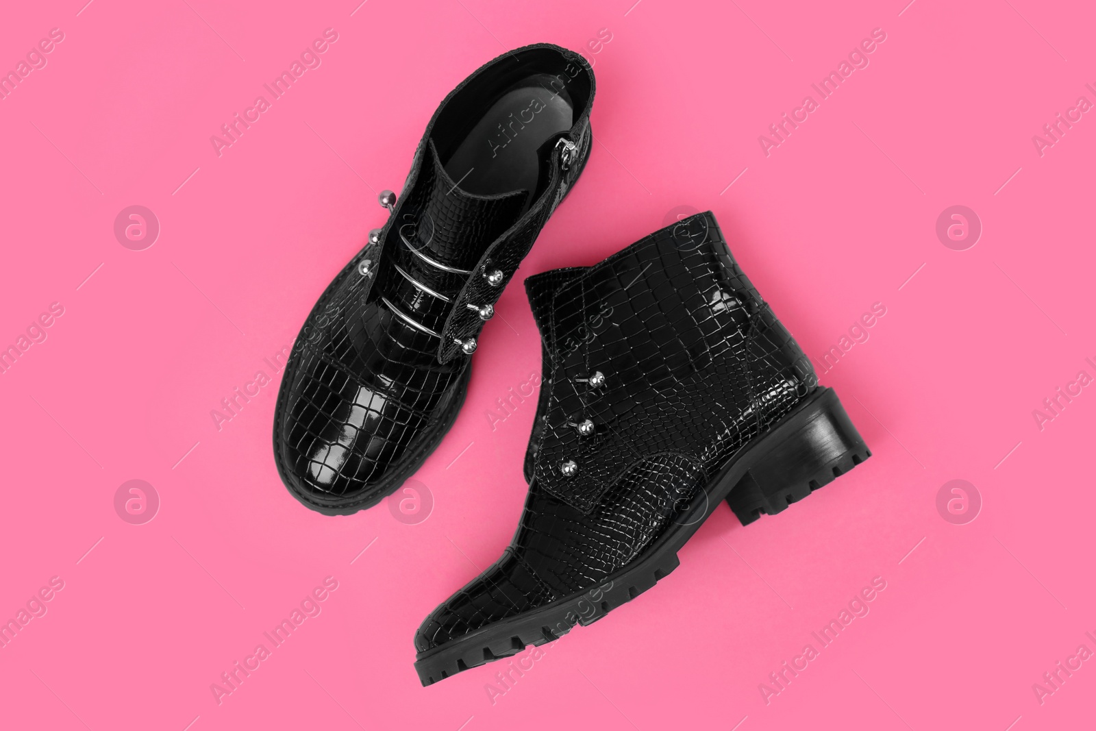 Photo of Pair of stylish ankle boots on pink background, top view