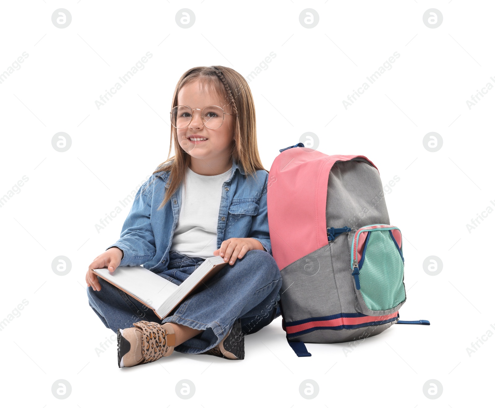 Photo of Cute little girl with book and backpack on white background