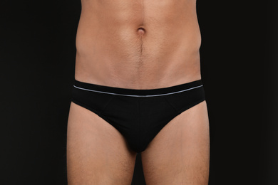 Photo of Man in underwear on black background, closeup