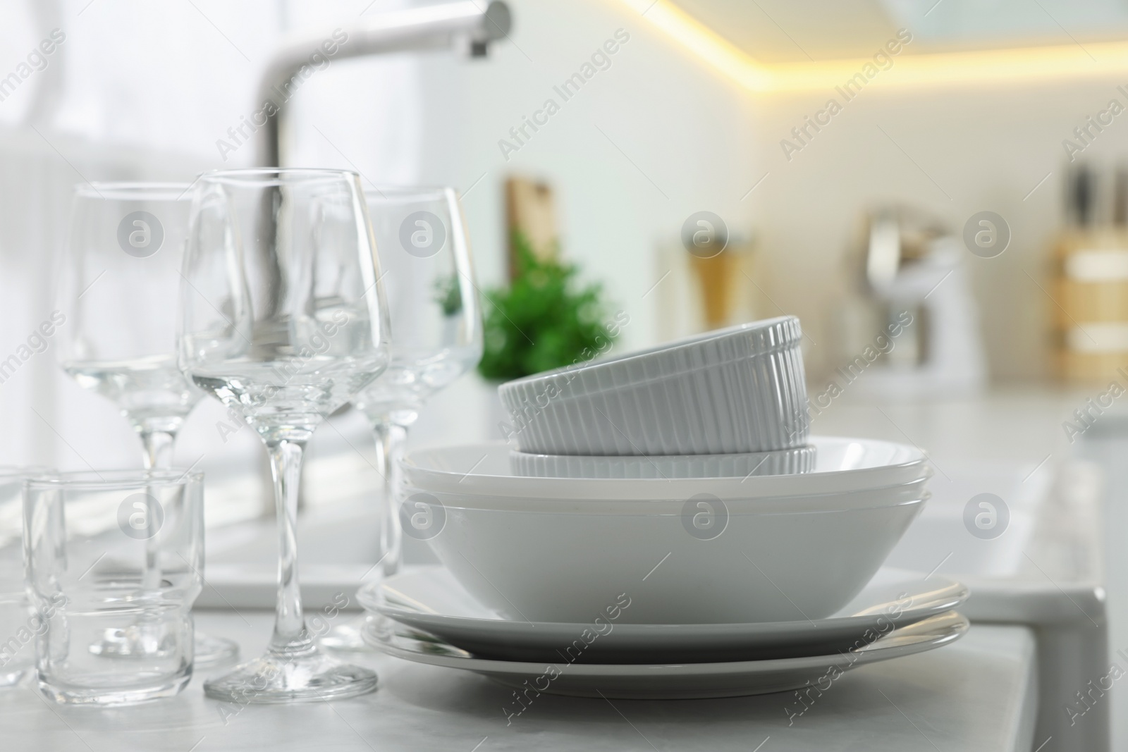 Photo of Different clean dishware and glasses on countertop in kitchen