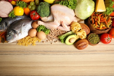 Photo of Different products on wooden table, top view with space for text. Healthy food and balanced diet