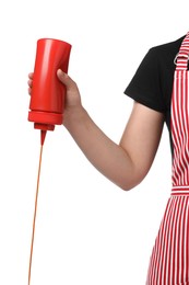 Photo of Woman pouring tasty ketchup from bottle on white background, closeup