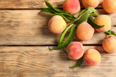 Fresh sweet peaches on wooden table, top view