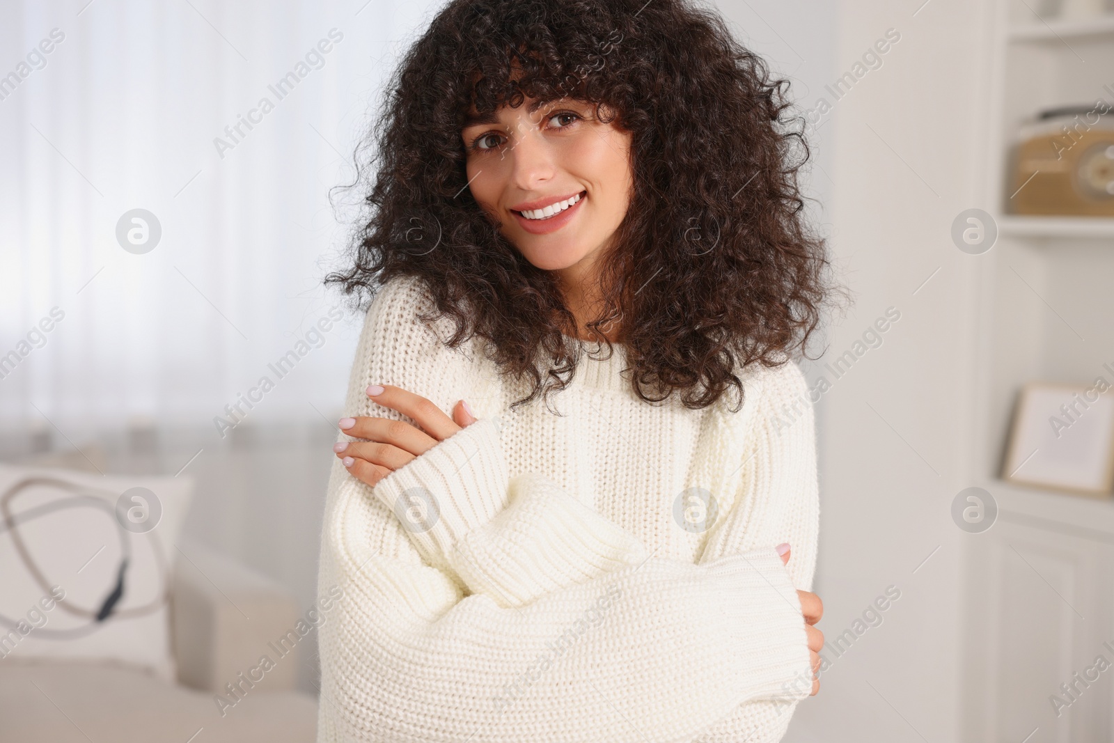 Photo of Happy young woman in stylish white sweater indoors