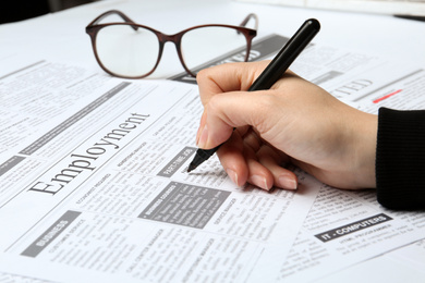 Woman marking advertisement in newspaper, closeup. Job search concept