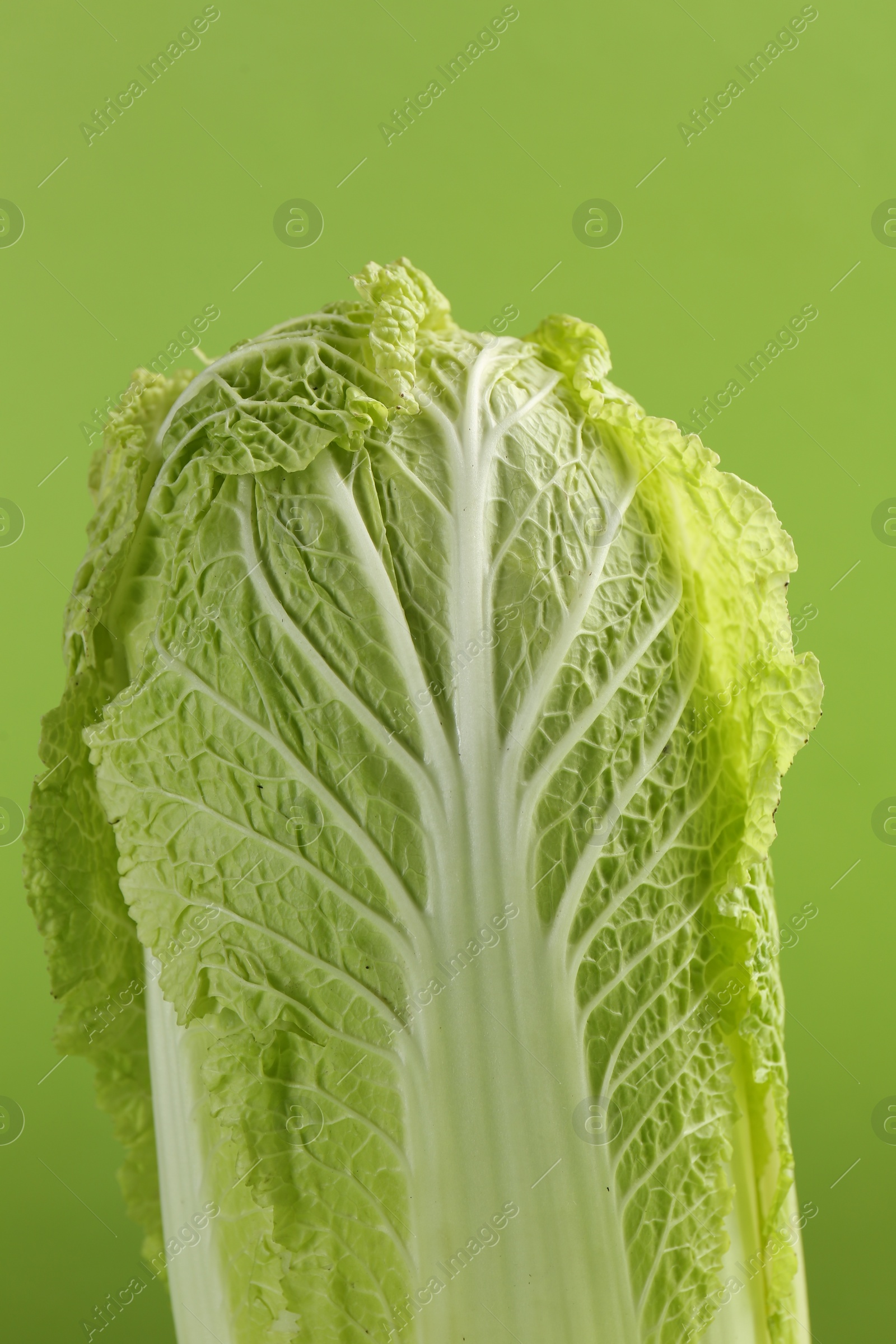 Photo of Fresh ripe Chinese cabbage on light green background, closeup