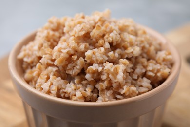 Photo of Tasty wheat porridge in bowl on table, closeup