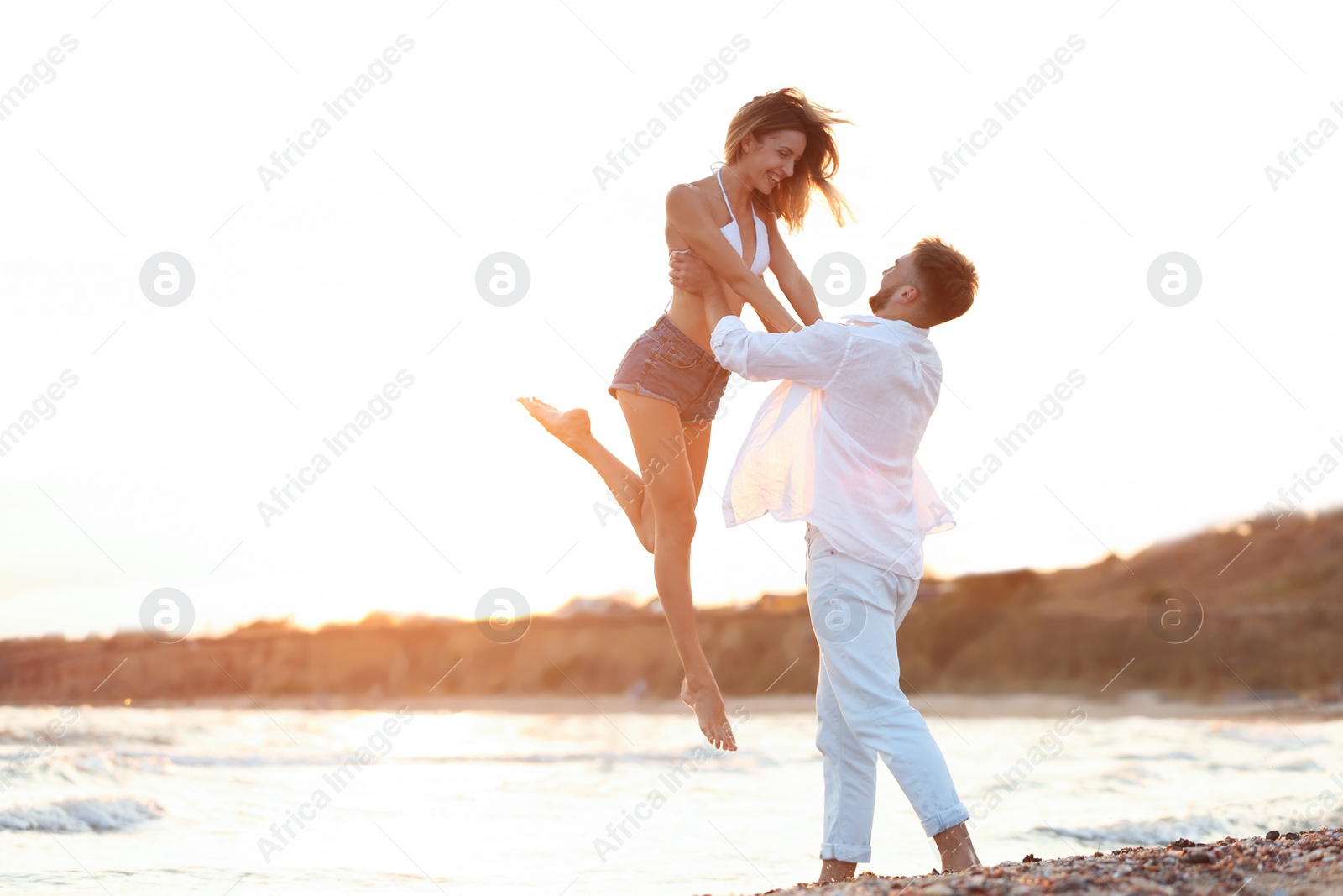 Photo of Young couple spending time together on beach