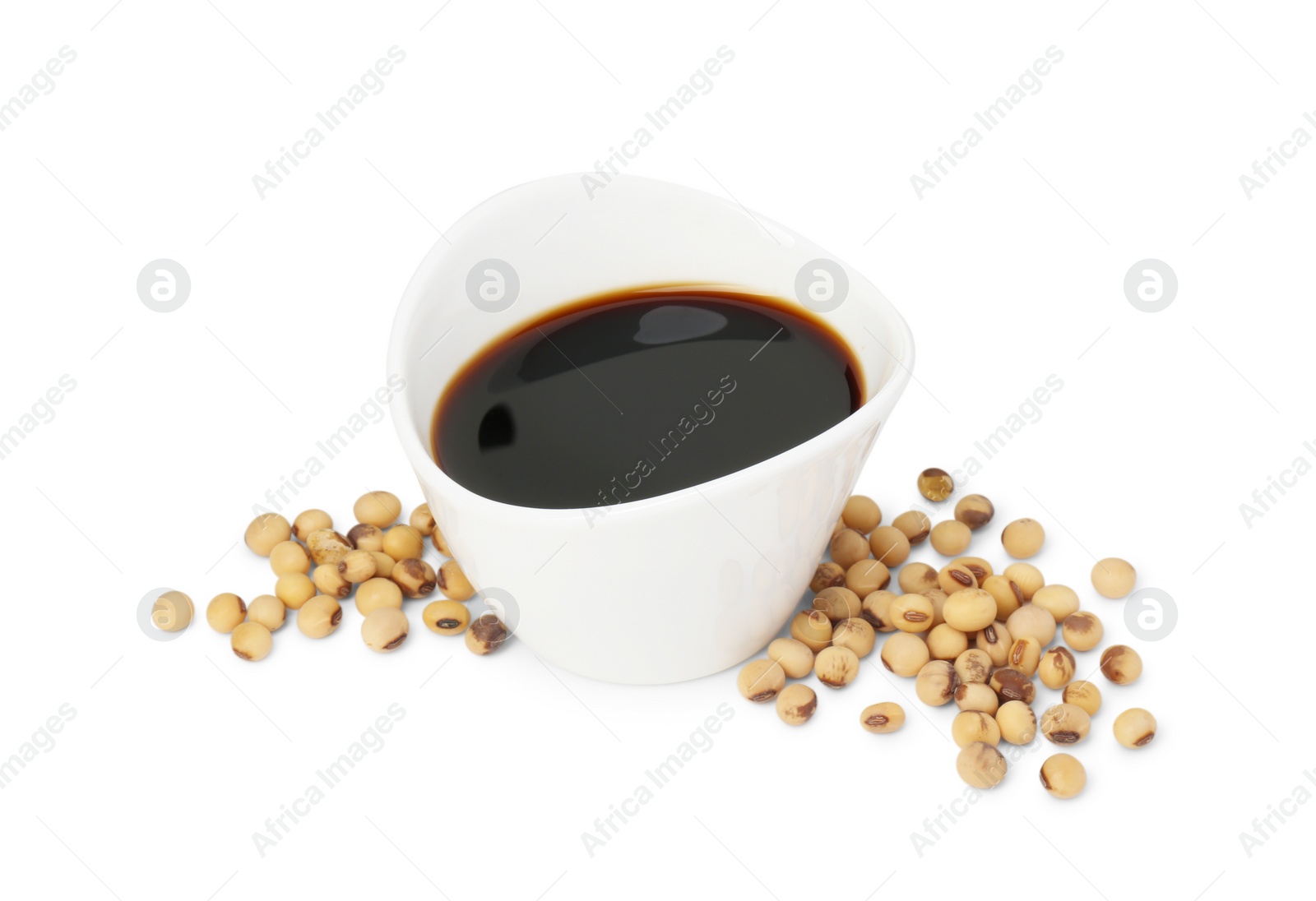 Photo of Tasty soy sauce in bowl and soybeans isolated on white