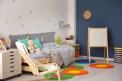 Photo of Modern child room interior with comfortable bed and armchair